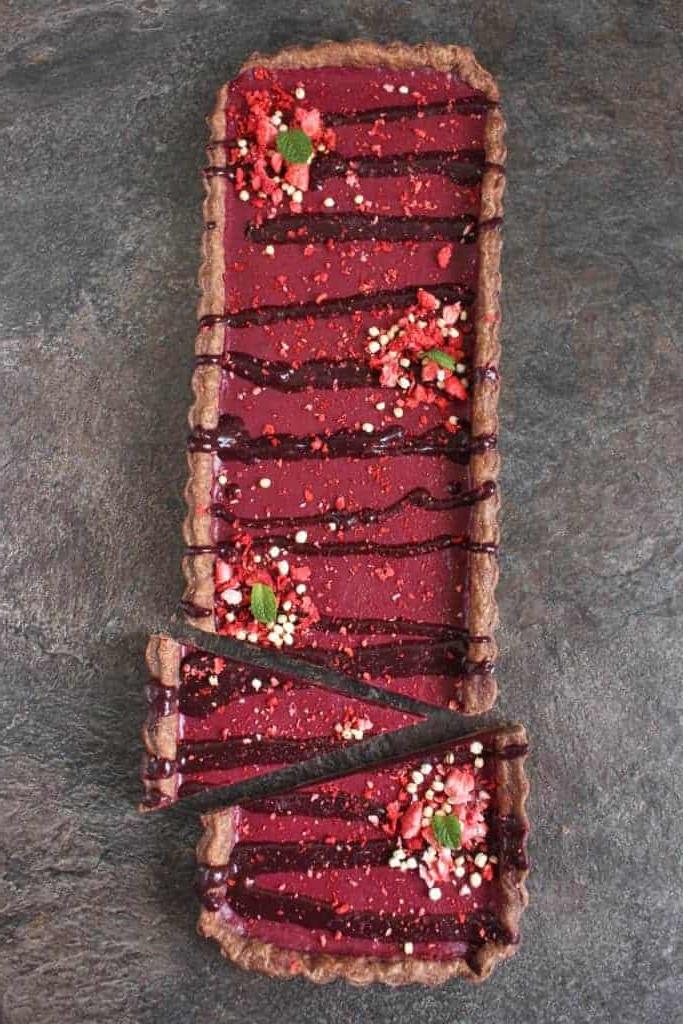Tart from above on a grey surface with a few slices cut off.