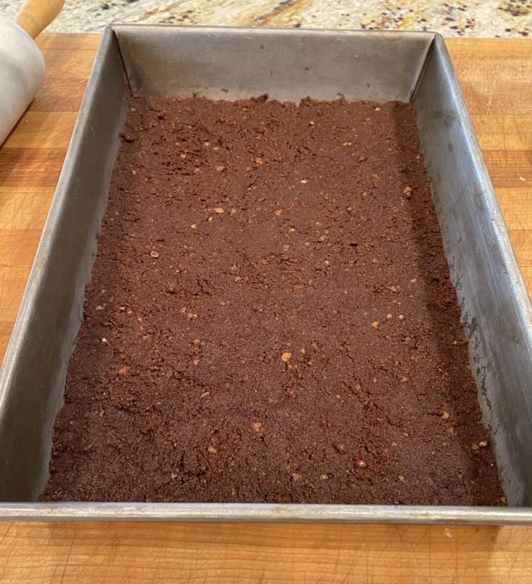 Chocolate vanilla wafer crust in a baking pan.