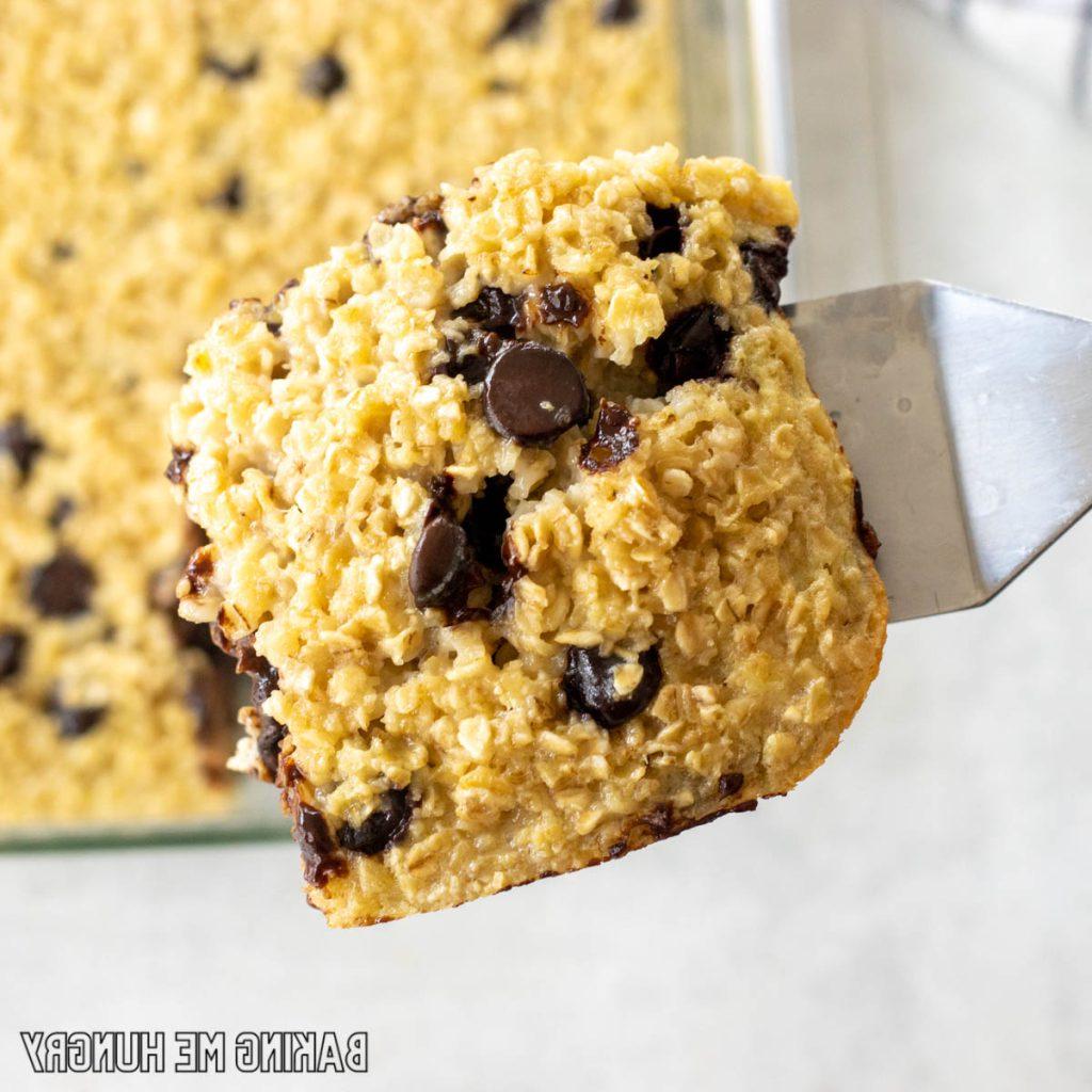 serving spatula lifting piece of baked chocolate chip oatmeal close up
