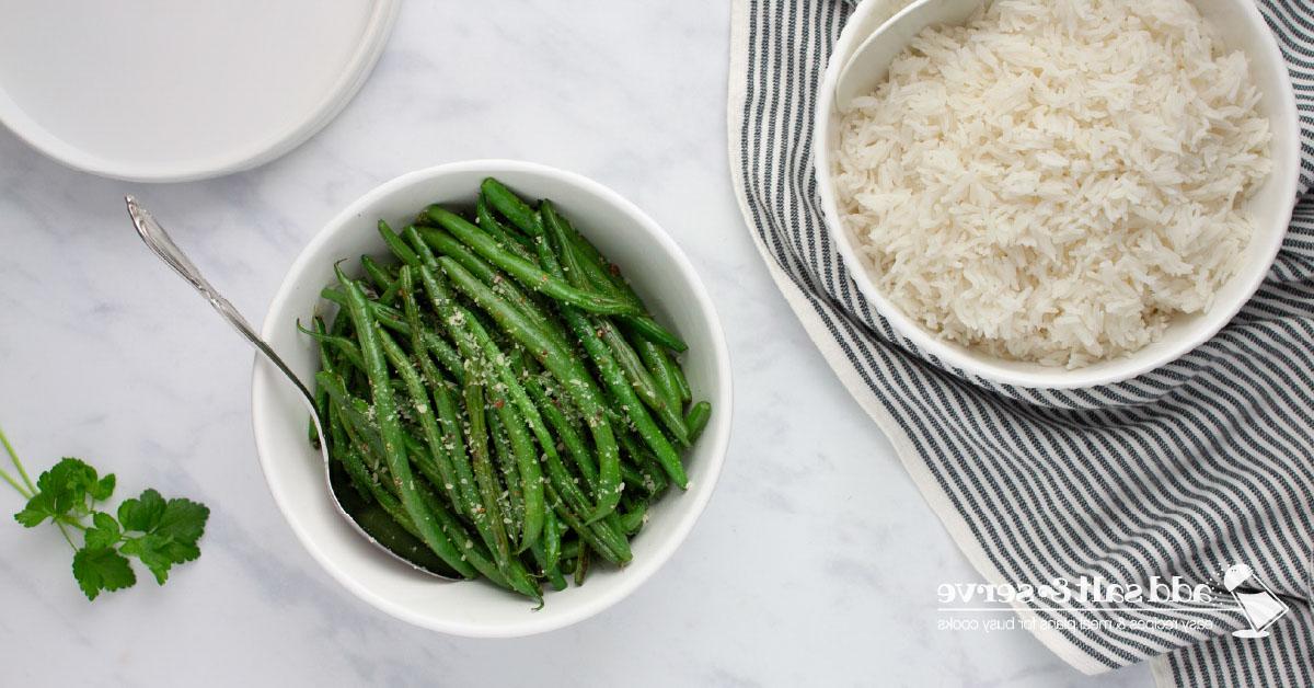 Green Beans Seasoned with Italian Dressing A serving bowl of cooked Seasoned Green Beans beside a serving bowl of white rice.