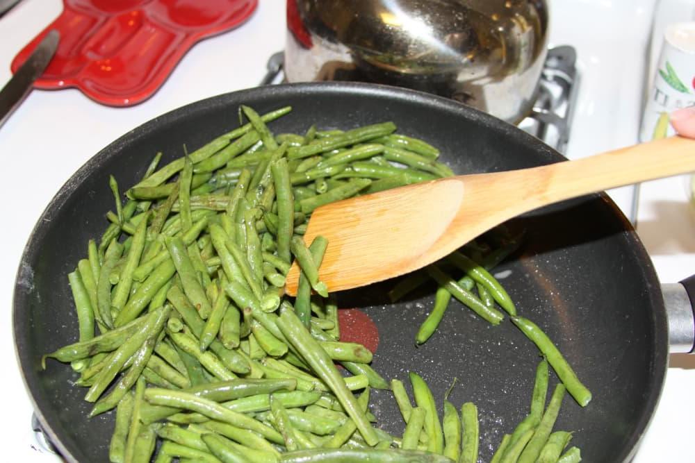 Green Beans Seasoned with Italian Dressing green beans being sautéed in a black frypan